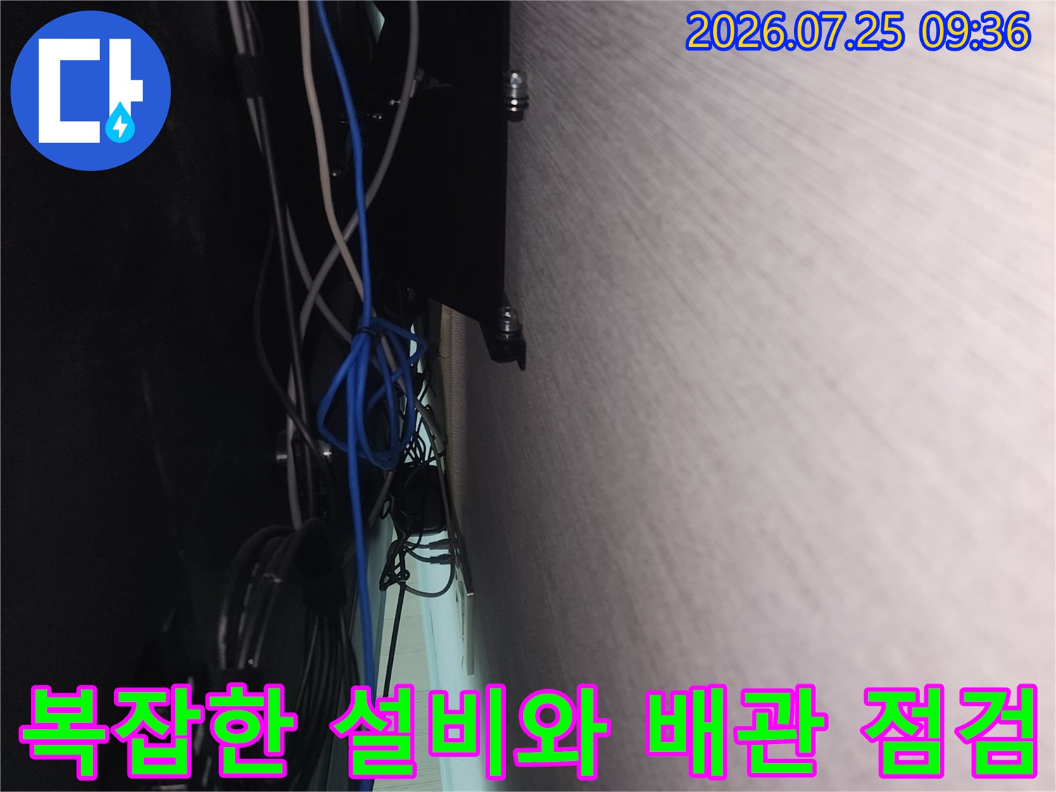 거실 벽면 내부의 전선과 배관이 뒤섞인 구간을 상세하게 촬영한 사진
