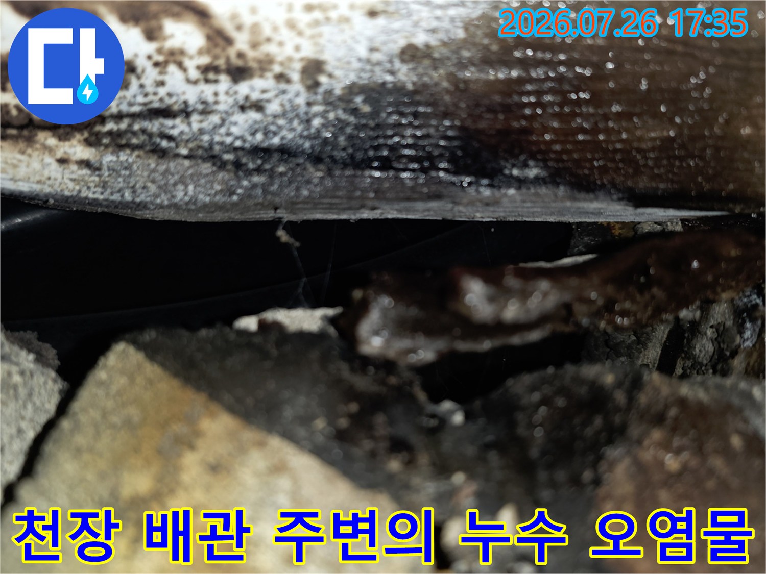콘크리트 천장 틈새와 배관 하단에 물이 고여 있고 변색된 누수 피해 현장의 모습