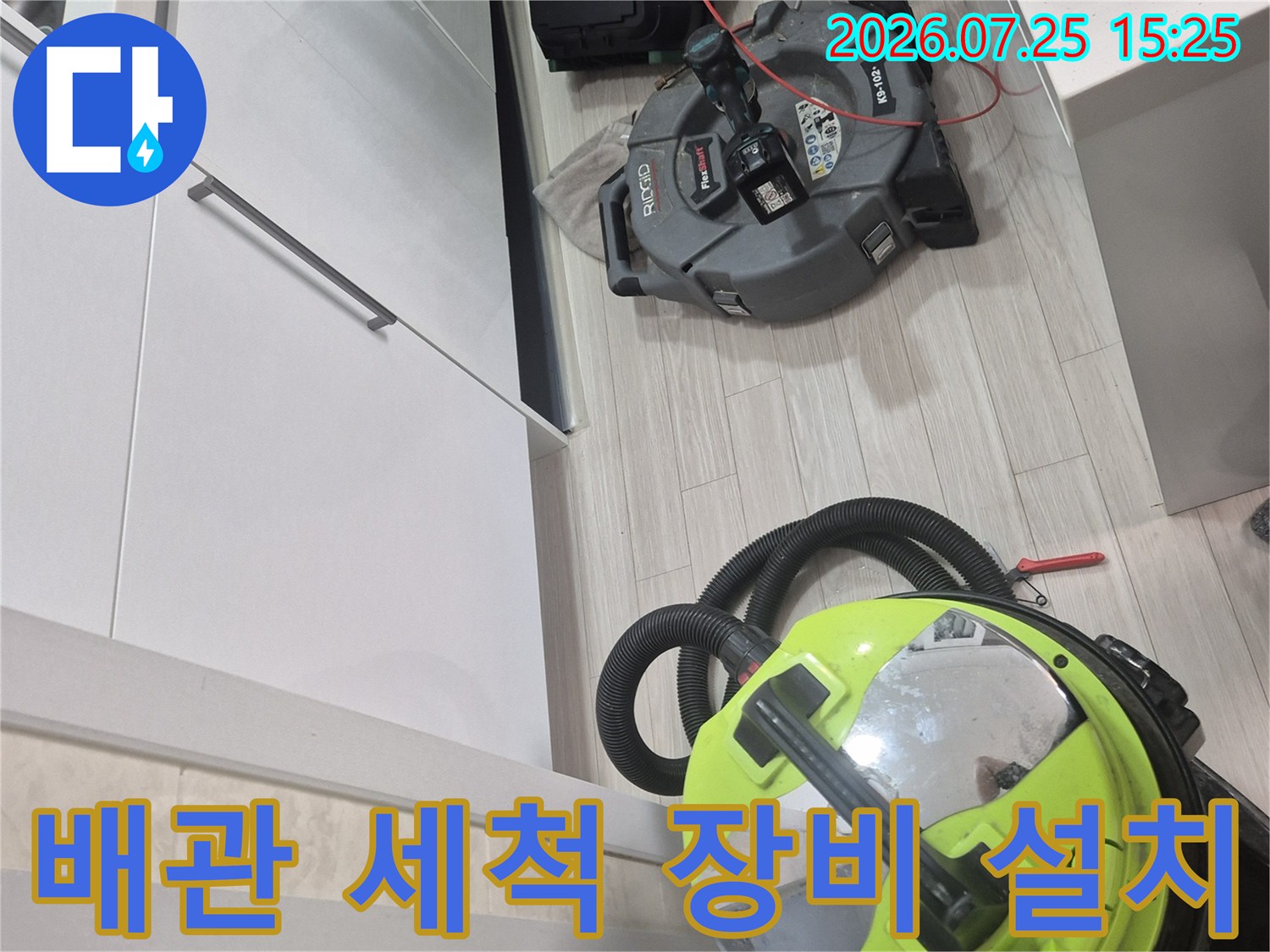 싱크대 하부에 배치되어 배수 불량 문제를 해결할 준비를 마친 석션 및 파쇄 도구