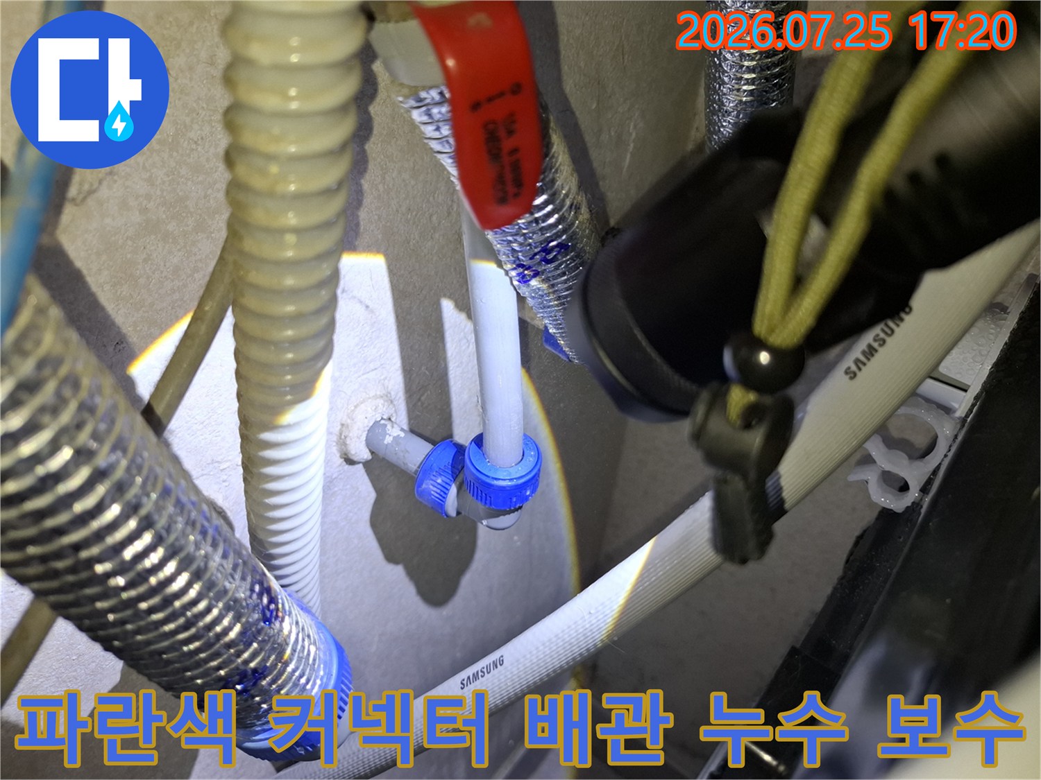 빨간색 핸들 밸브와 파란색 플라스틱 커넥터가 연결된 배관 시스템-누수 수선 부위