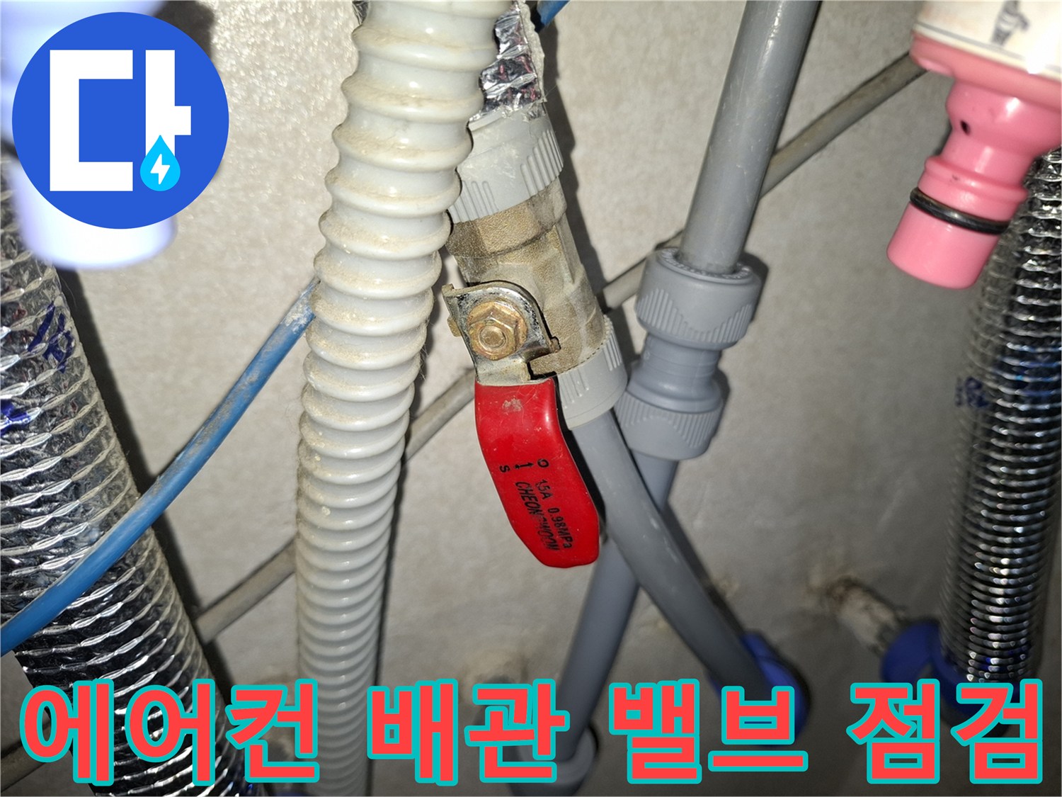 빨간색 핸들이 있는 밸브와 회색 에어컨 배관의 연결 상태