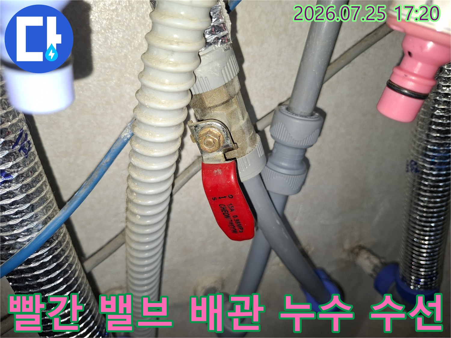 회색 플라스틱 주름관과 빨간색 조절 밸브가 결합된 부분의 상세 사진