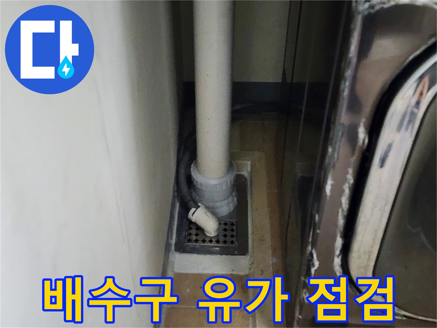 바닥 배수 덮개와 수직 배관이 연결된 부위를 근접 촬영한 사진입니다.