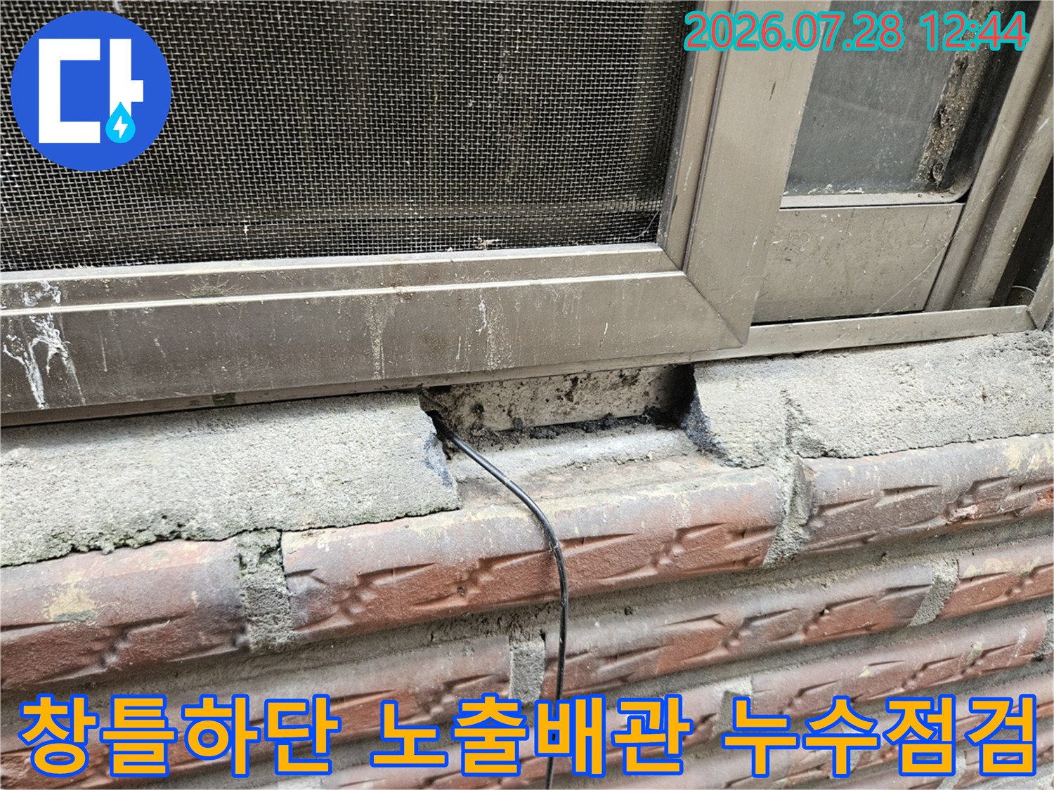 창문 틀 하부의 파손된 콘크리트와 외부로 노출된 배선이 보이는 현장 사진
