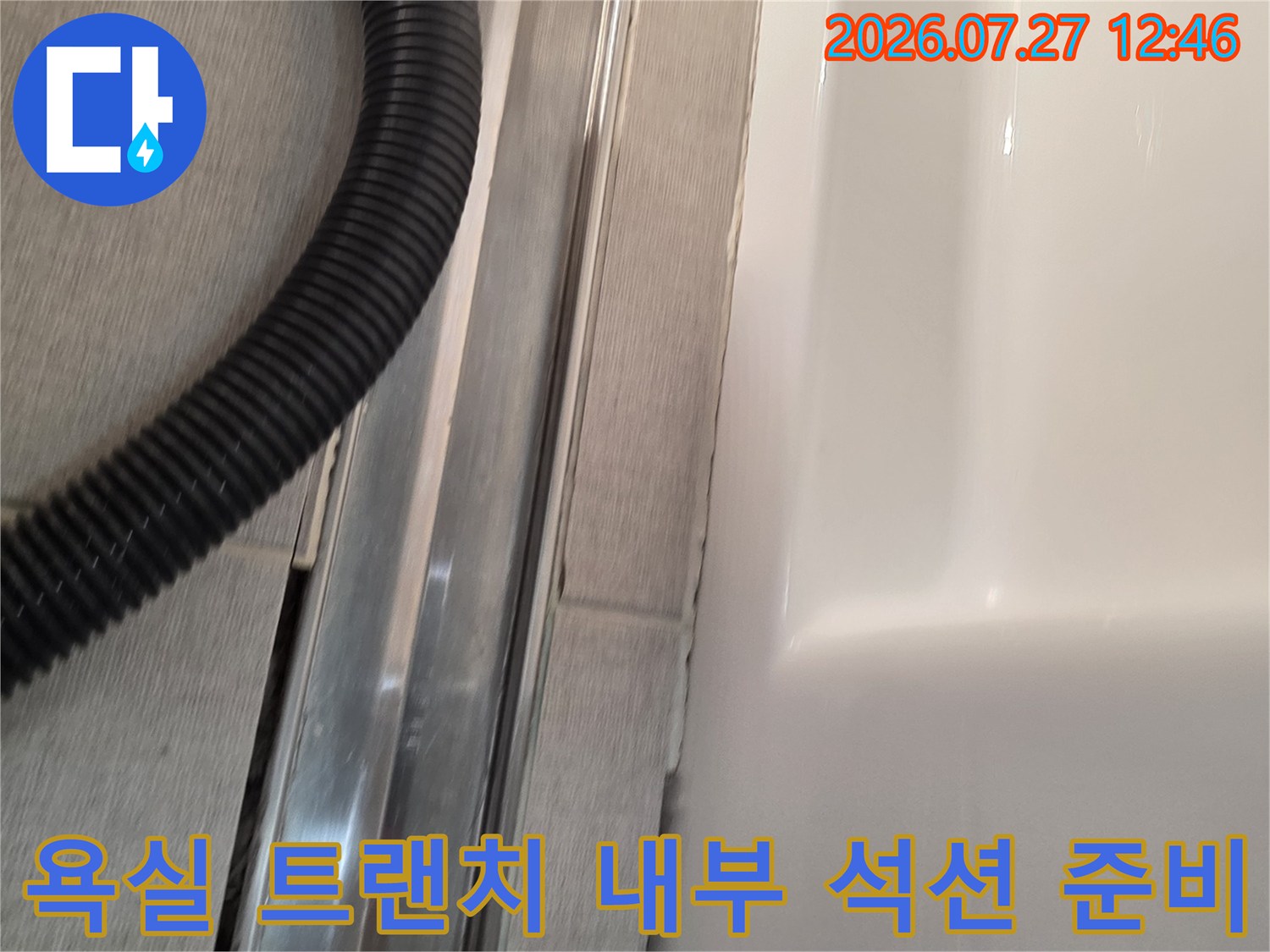 금속-배수-트랜치가-설치된-욕실-바닥과-작업용-검정색-석션-호스