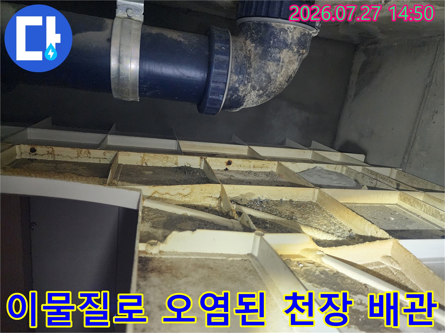 천장 속에 설치된-변색되고 오염된 파란색 PVC 배관과 주변 구조