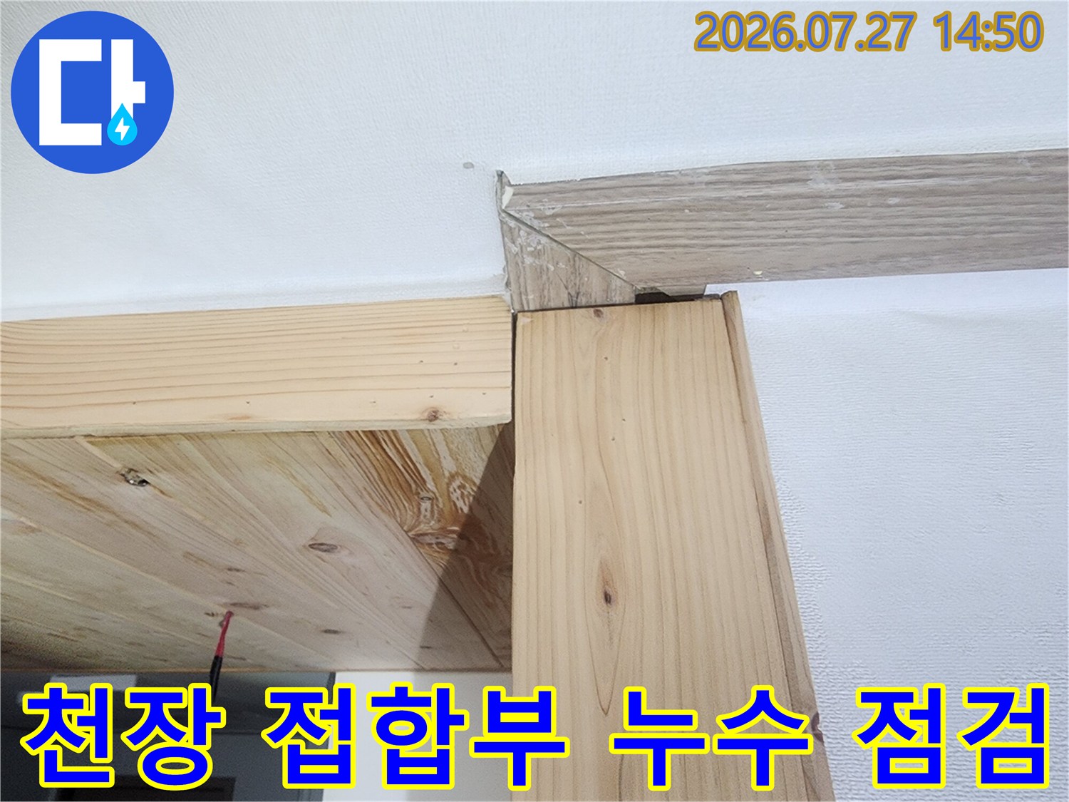 흰색 천장재와 목재 지지대가 연결된 모서리 부분의 정밀 사진