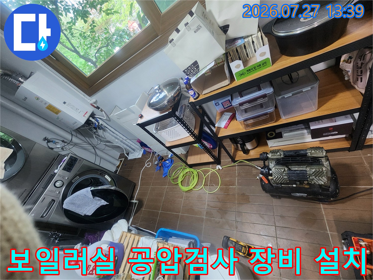 세탁기와 보일러가 있는 다용도실 바닥에 배치된 누수 탐지용 공압 검사 장비-노란색 호스 연결 상태