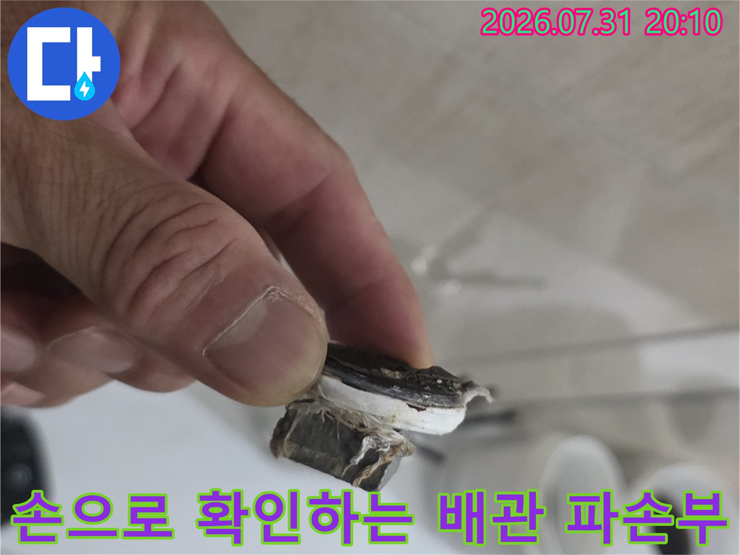 파손된 노후 직수 배관을 손에 들고 세부 상태를 체크하는 장면