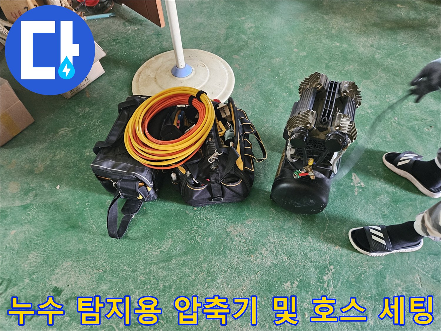 배관 누수 여부를 확인하기 위해 준비된 노란색 호스와 공기 압축기 장비