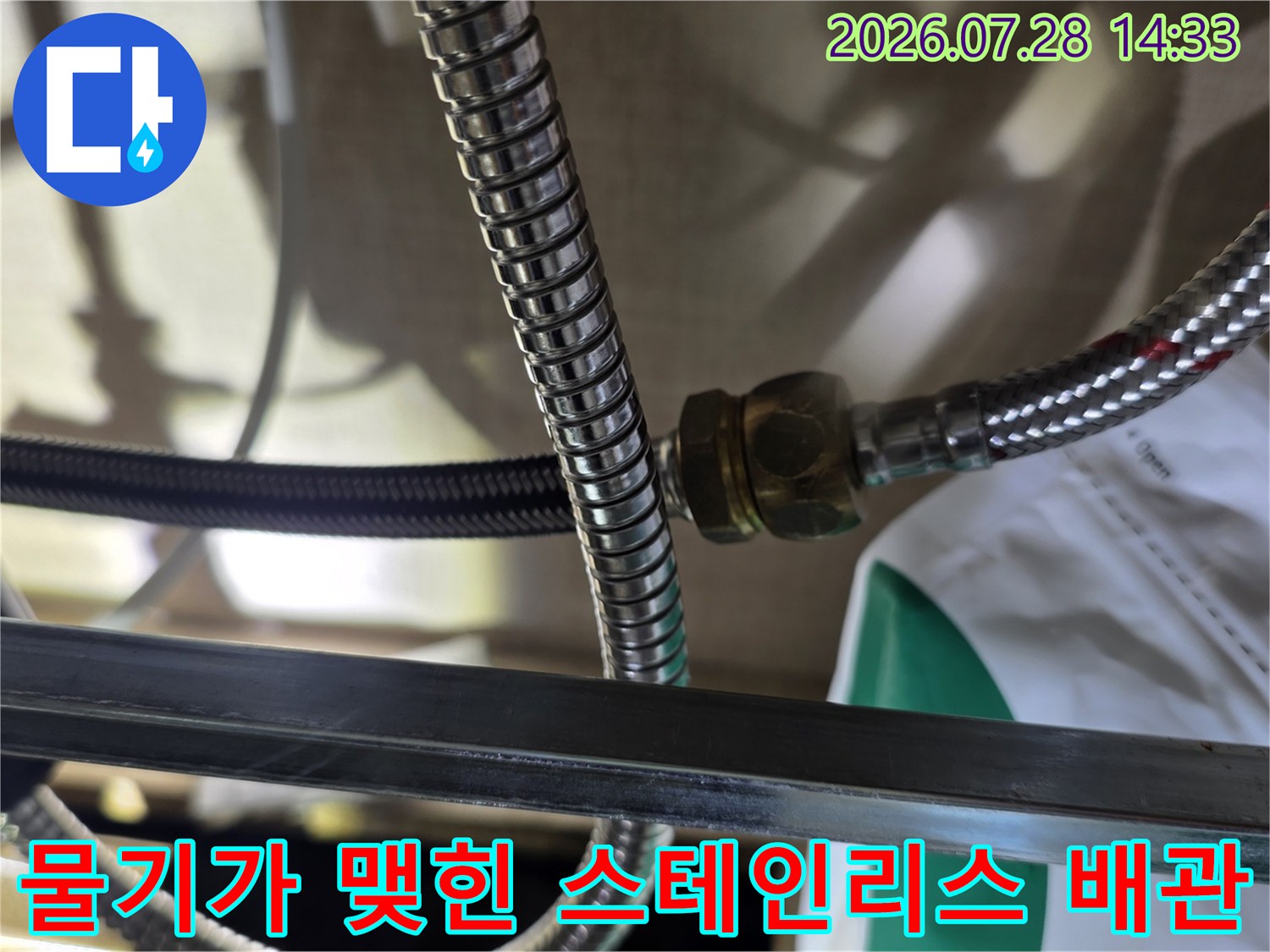 싱크대 하부 주름관 연결 너트 부위에서 미세하게 누수가 발생하는 모습
