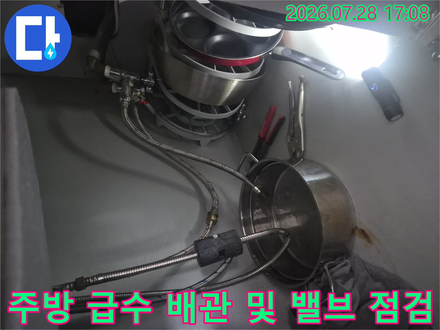싱크대 밑에 위치한 식기세척기용 분배 밸브와 호스 연결부 상태 촬영