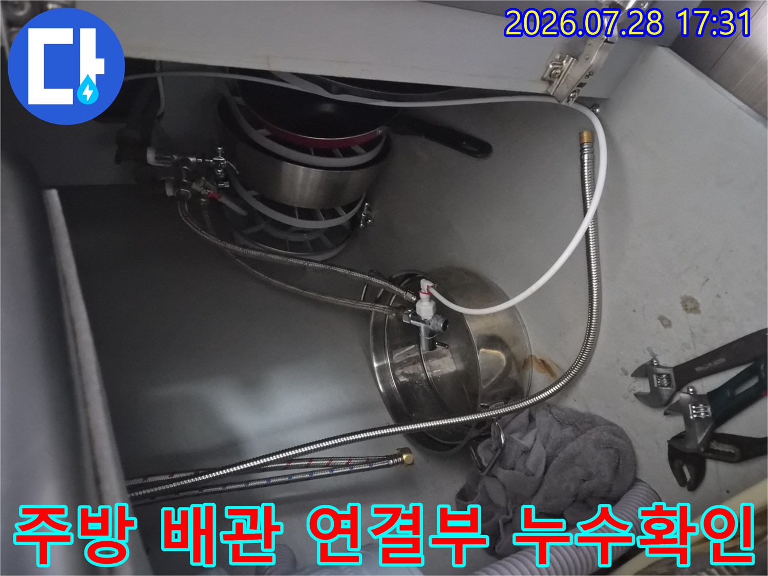싱크대 하부에 복잡하게 얽힌 배관 및 수선 부위 점검 사진