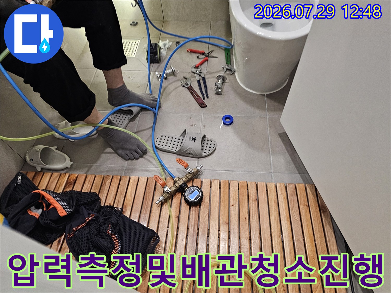 전문 세척 장비와 압력 게이지를 연결하여 배출구를 점검하는 모습