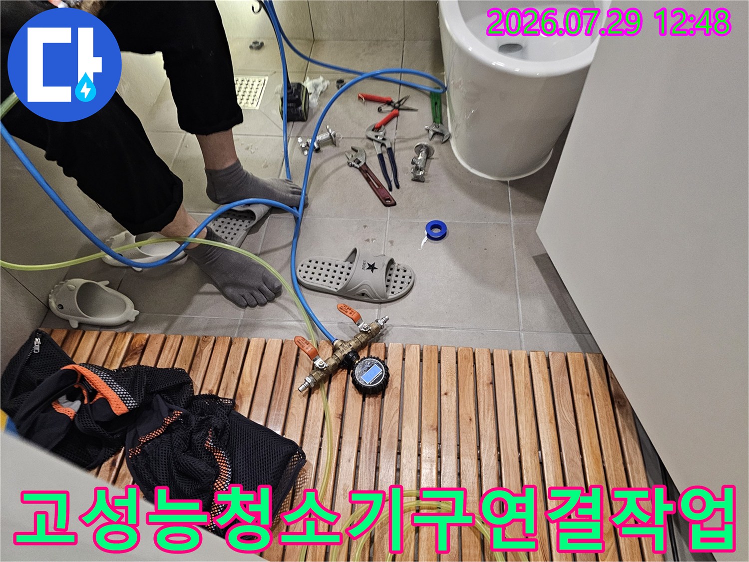 전문적인 배수 시스템 점검 장비를 활용해 싱크대 하부를 정비하는 장면
