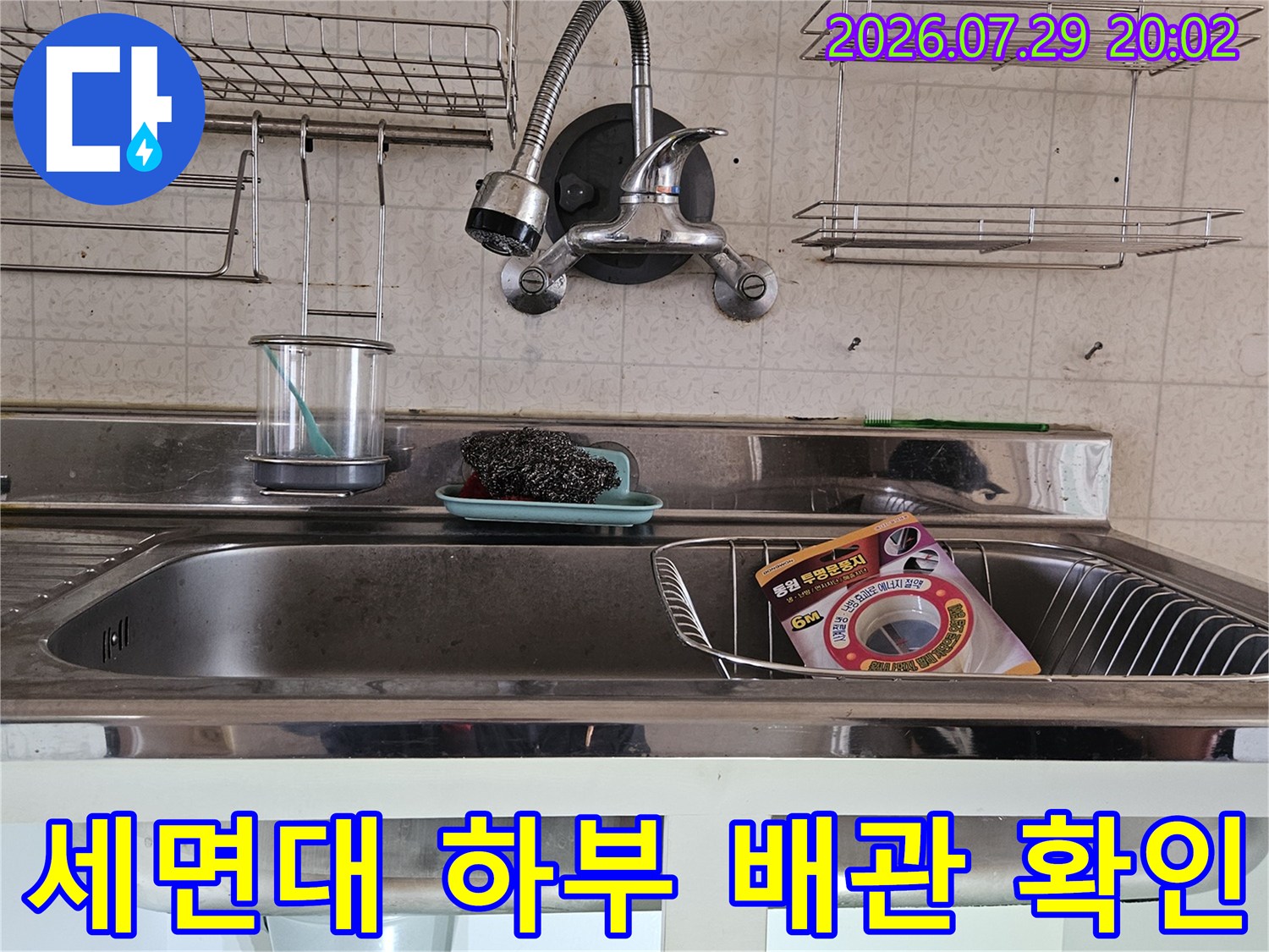 세면대 아래 수전과 연결된 금속 및 고무 호스 부위를 집중 점검하는 모습