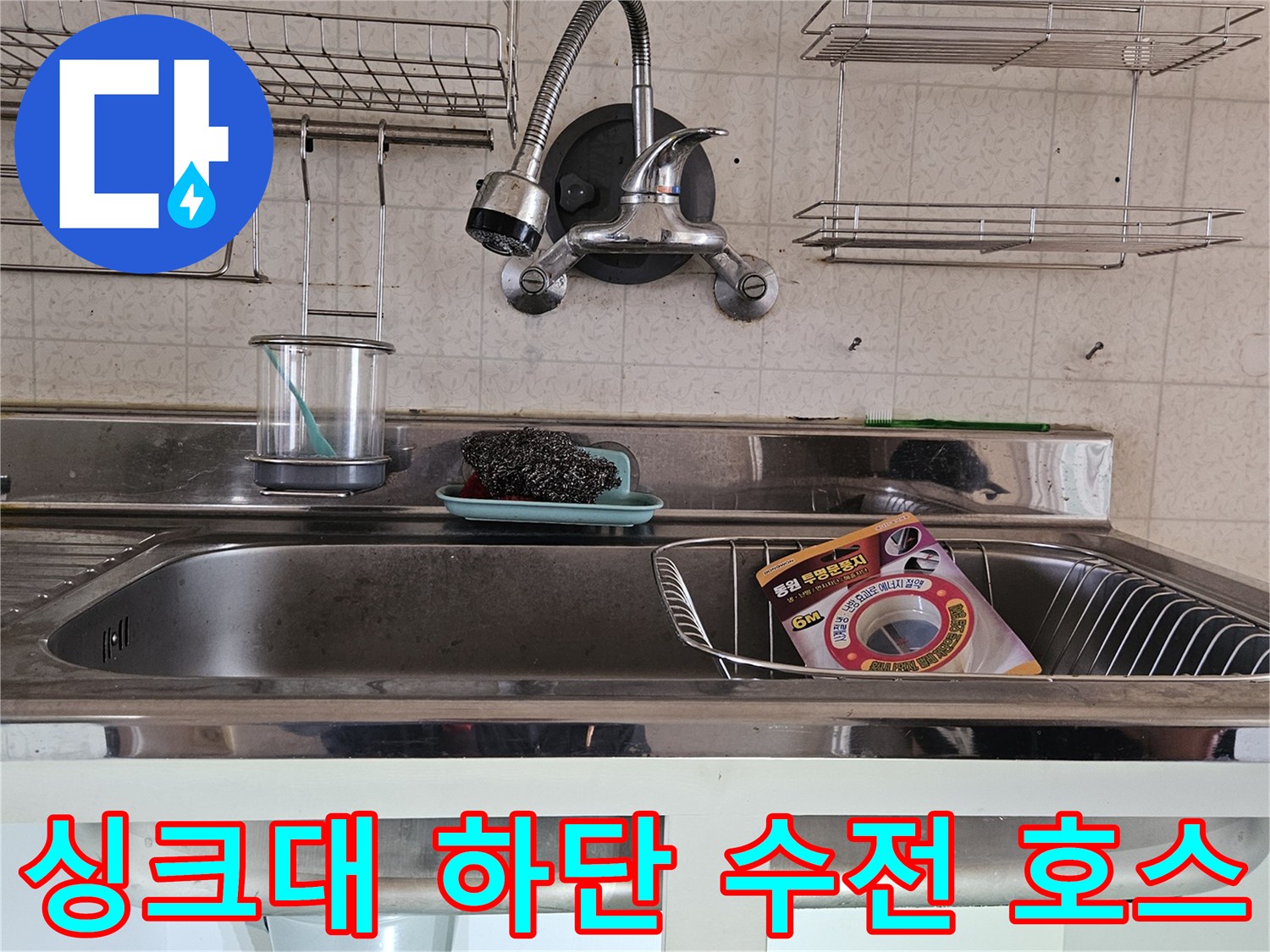 싱크대 아래쪽의 수전 연결 부위와 주변 배관 구조를 보여주는 사진입니다.