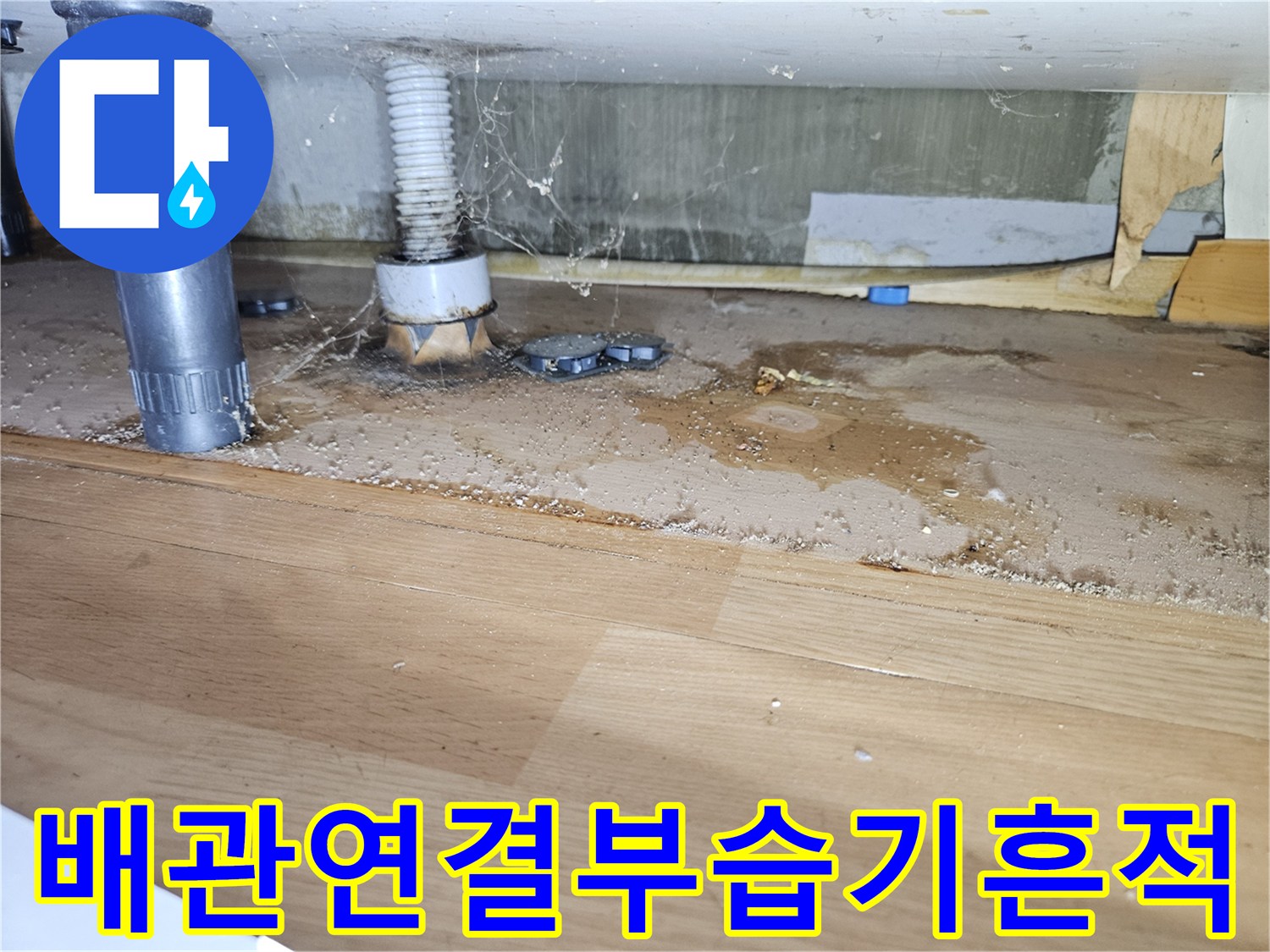 싱크대 하부장 아래 배관 부근의 젖은 흔적과 배관 구조
