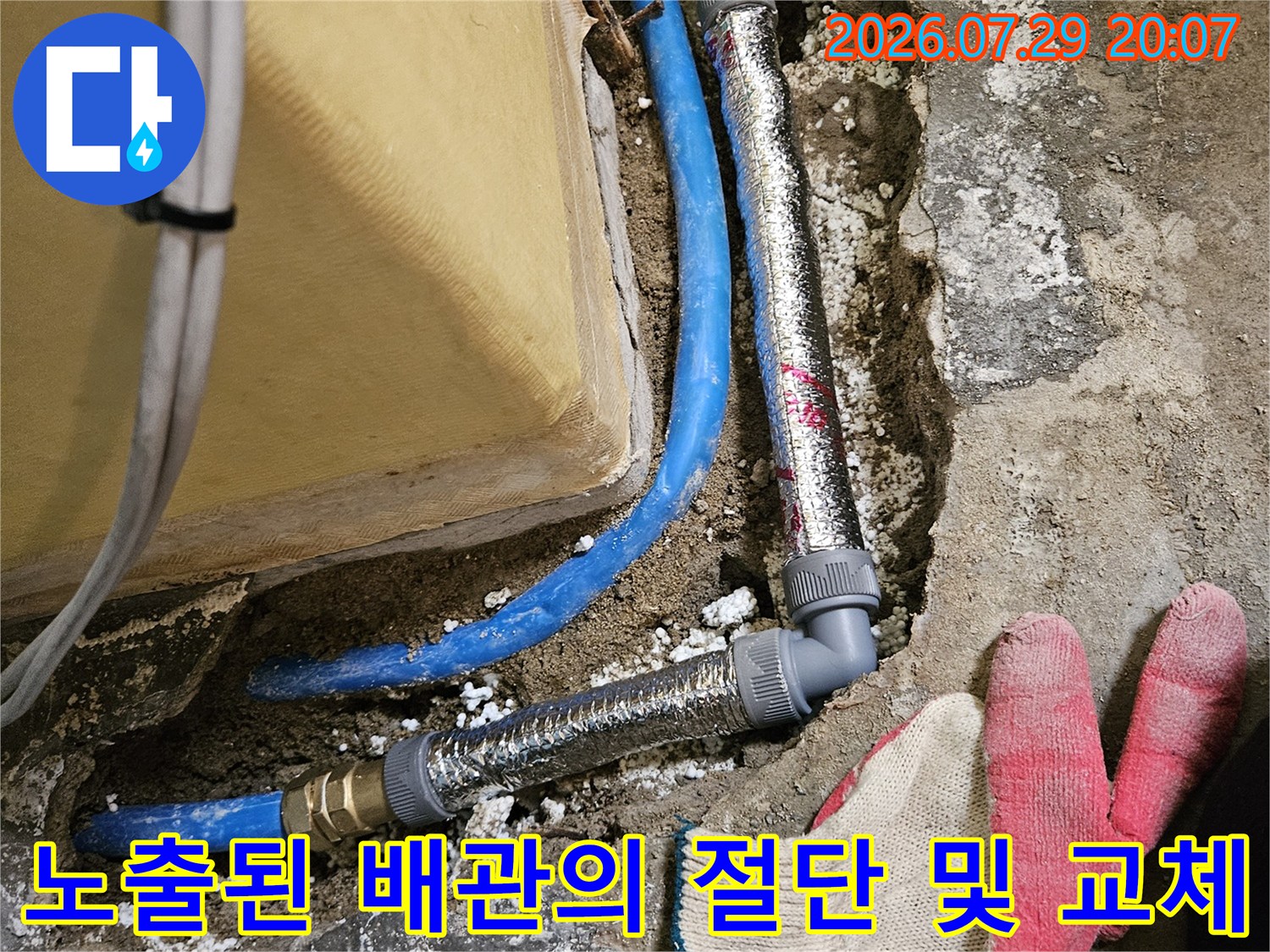 바닥 파손 부위에서 노출된 파란색 수도배관과 단열재를 활용한 보강 공사