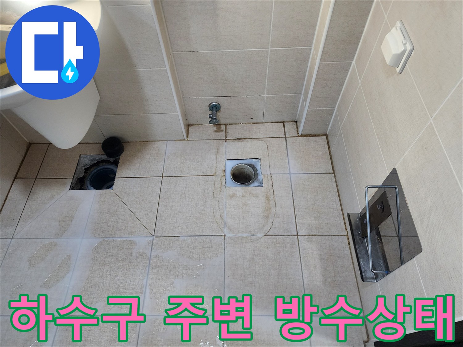 화장을실 배수구 유가 주변의 타일 틈새와 물기 상태를 보여주는 사진입니다.