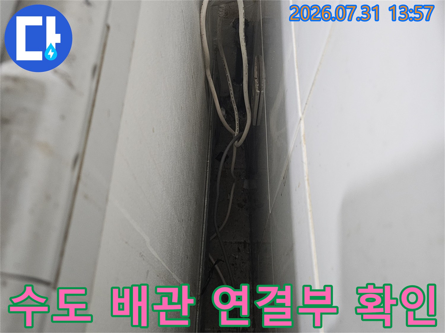 하얀색 수도 배관이 겹쳐진 구간의 연결 부위를 근접 촬영한 사진
