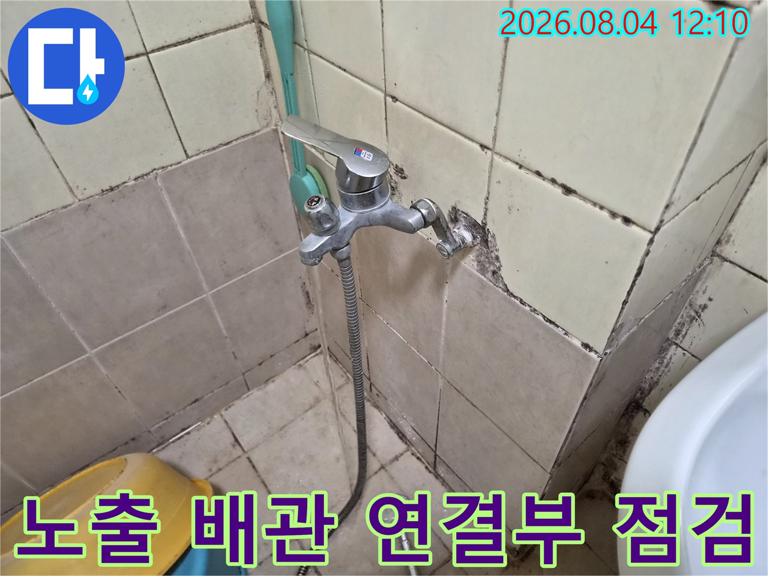 벽면에 설치된 수도꼭지와 수전 호스 주변의 누수 여부를 확인하는 공사 장면