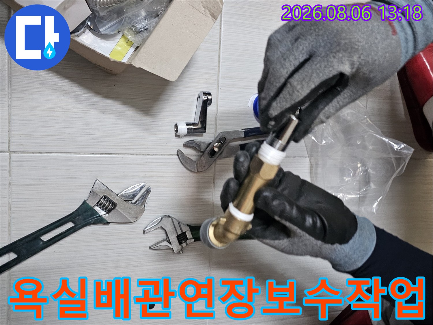 장갑을 착용하고 몽키스패너로 욕실 수전 연결 부위의 황동 배관을 조절하는 모습
