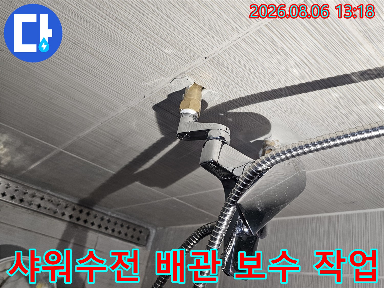 화장실 타일 벽면의 샤워기 수전 연결 부위와 금속 배관을 점검하는 모습