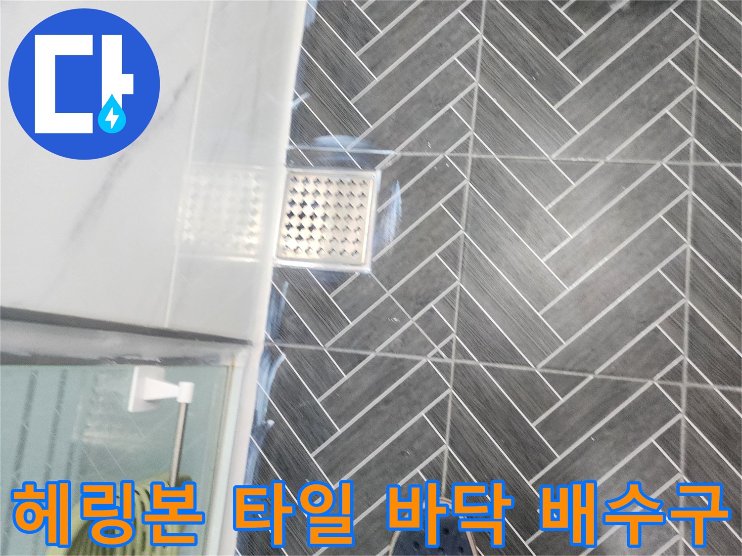 회색 헤링본 타일과 스테인리스 배수구 유가