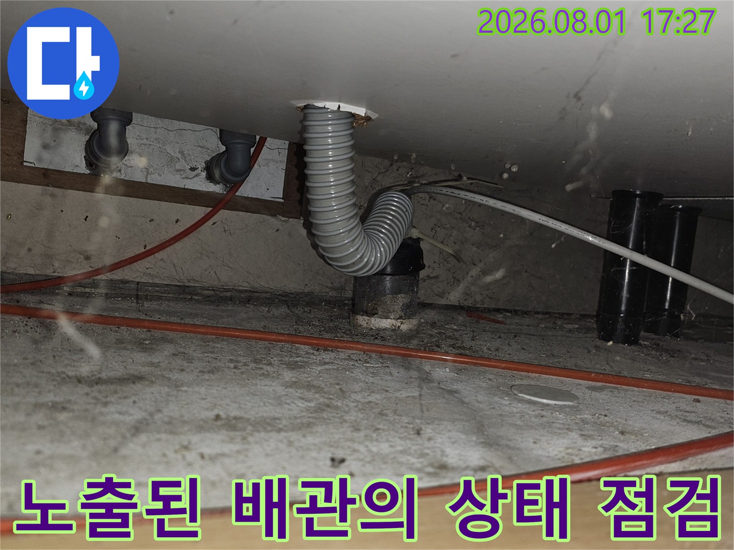 싱크대 하부에 위치한 회색 유연 호스 및 연결 파이프 시스템 확인