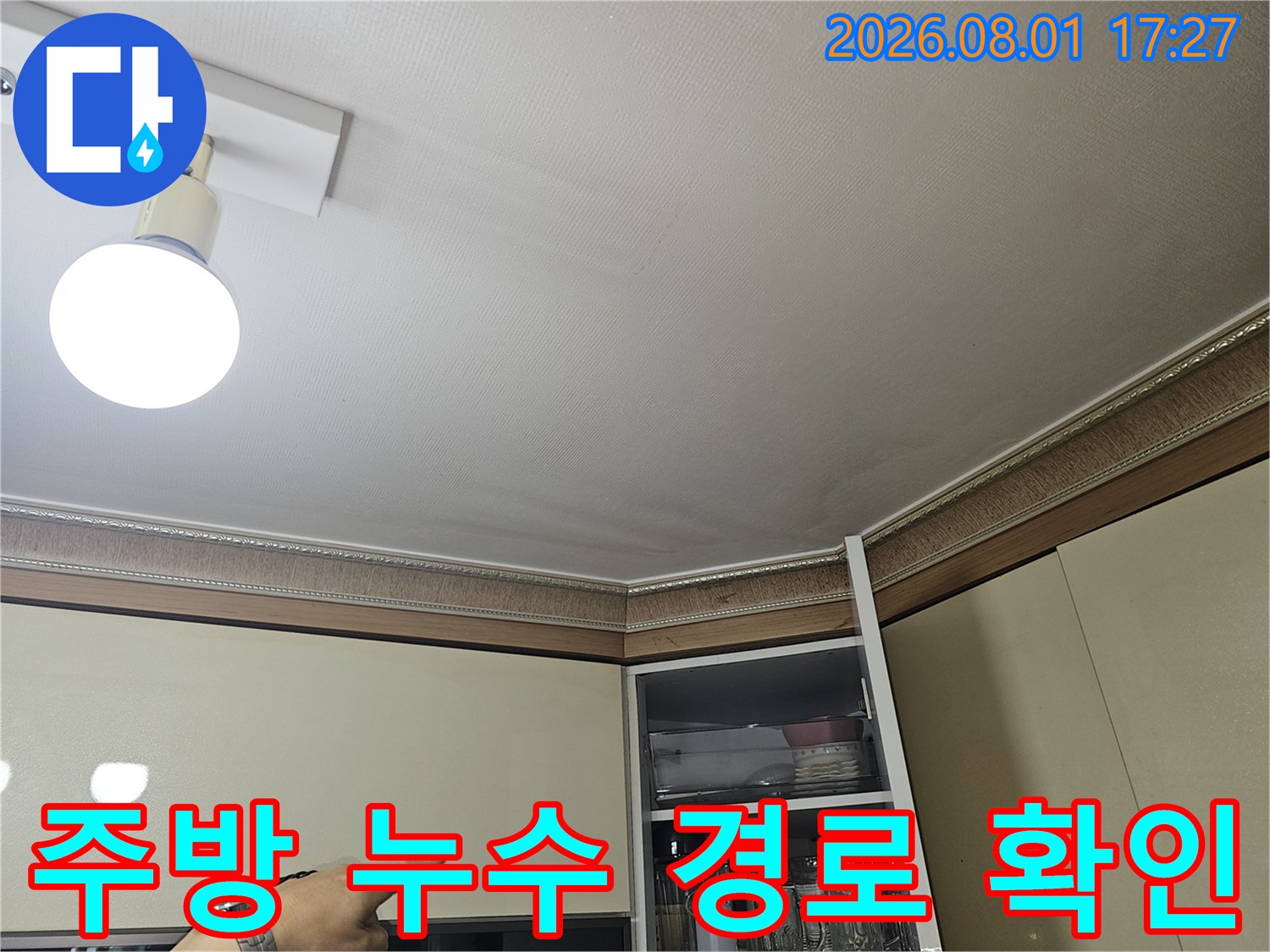 조명이 켜진 상태에서 주방 천장과 벽면의 누수 가능 구간을 점검합니다.