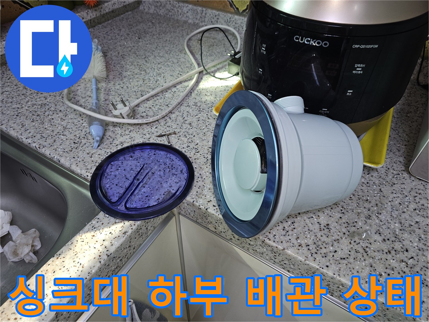 주방 싱크대 아래쪽의 배관 주변부를 근접하여 촬영한 사진입니다.