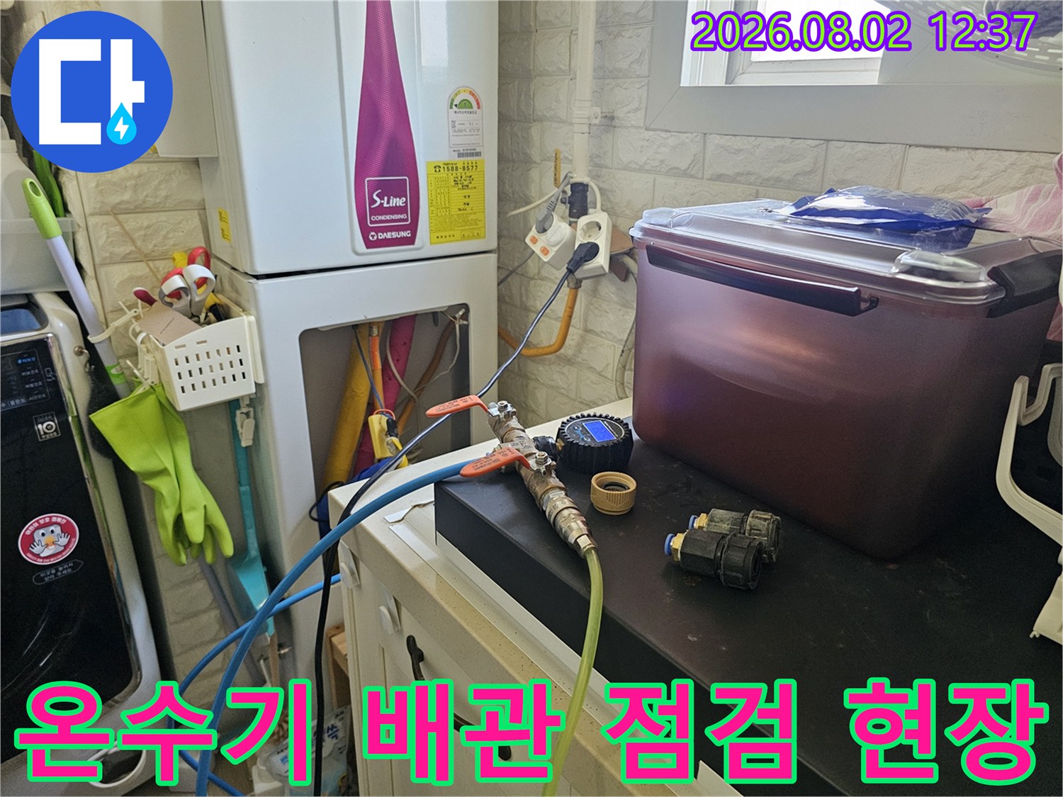 온수기 하단부 배관을 정밀 진단하고 있는 기술자의 작업 모습