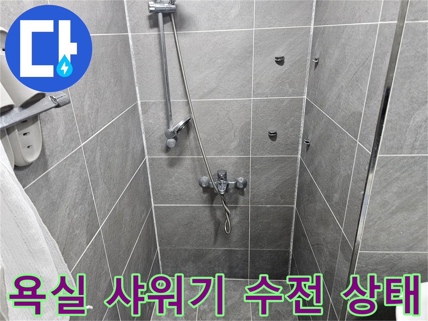 회색 타일 벽면에 설치된 샤워기 수전과 호스 모습