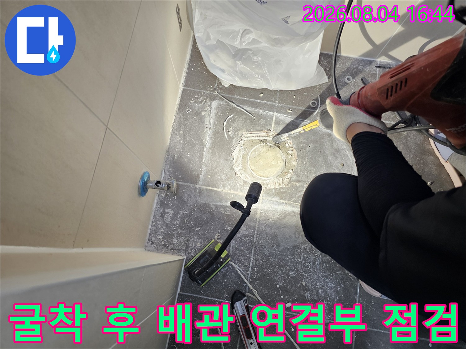 타일을 걷어낸 자리에서 노출된 배관 소켓과 주변을 세밀하게 점검하는 장면