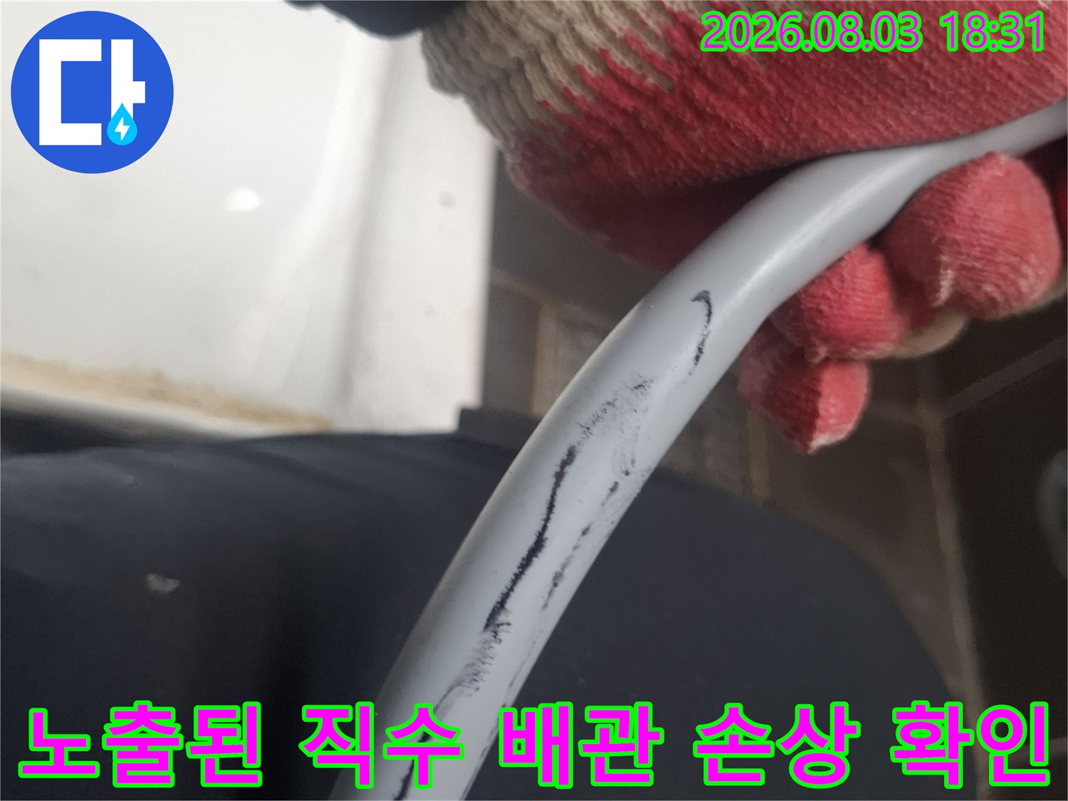 작업자가 장갑을 끼고 노출된 파손 배관의 상태를 점검하는 모습
