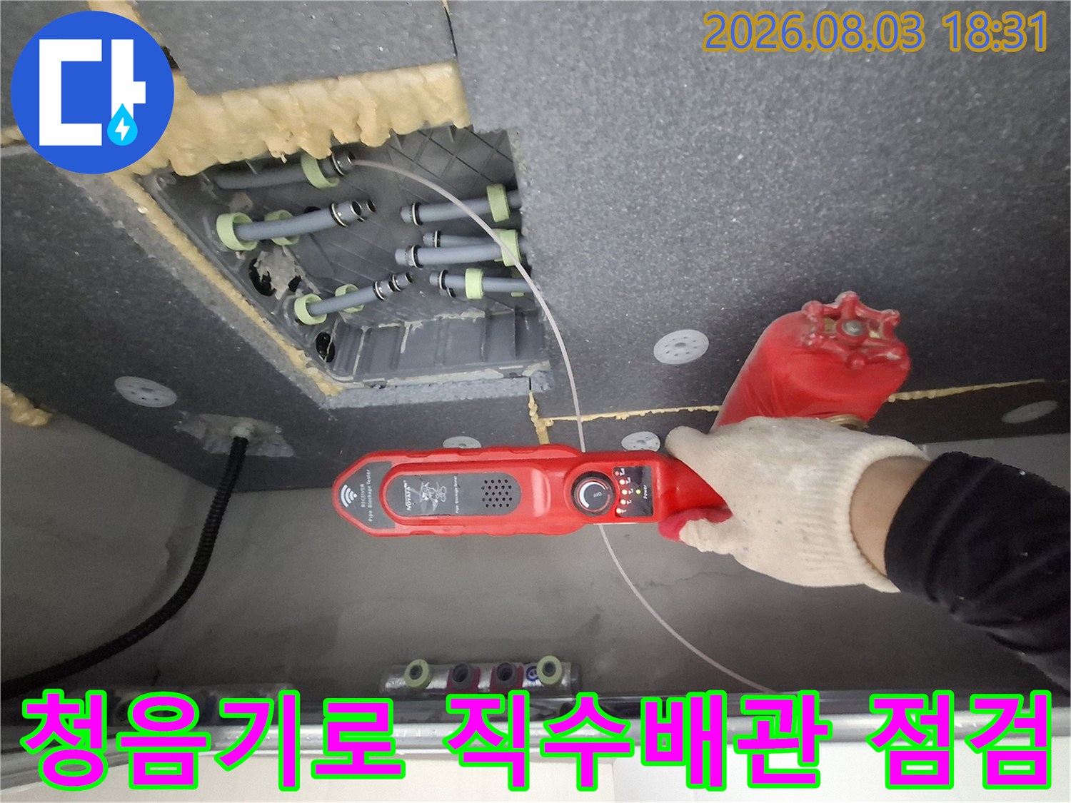 천장 안의 배관 시스템을 청음 장비로 정밀하게 체크하여 누수 지점을 찾는 장면