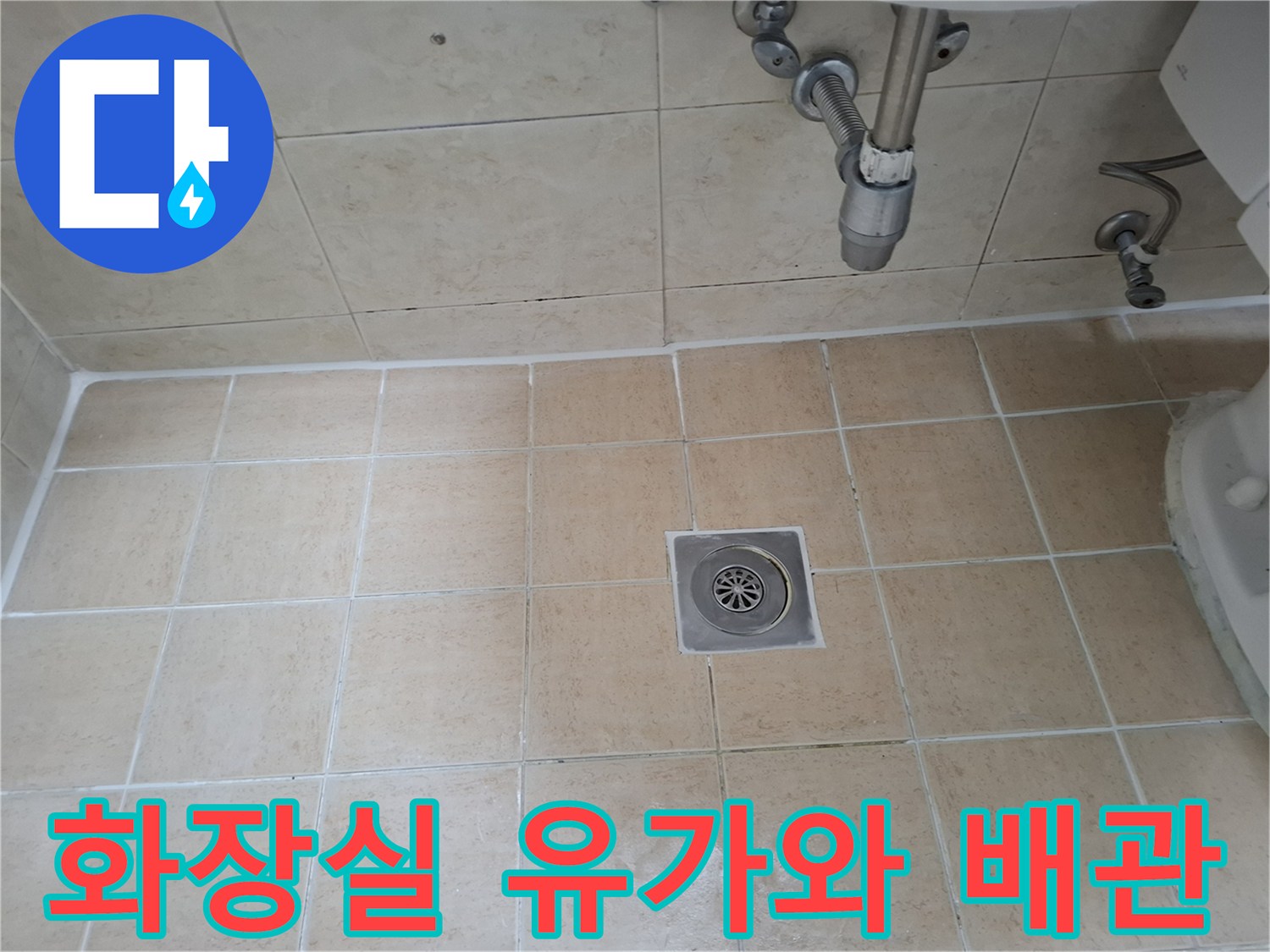 욕실 바닥의 스테인리스 유가와 상단 배관의 연결 상태를 촬영한 이미지입니다.