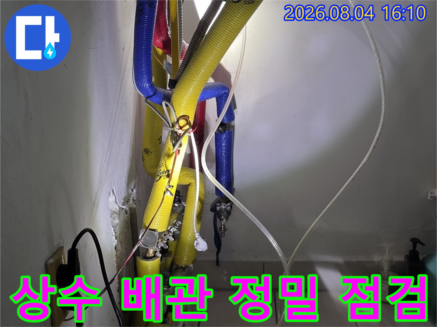 공압 게이지와 연결된 호스를 사용하여 상수 배관의 압력 저하를 체크하는 모습