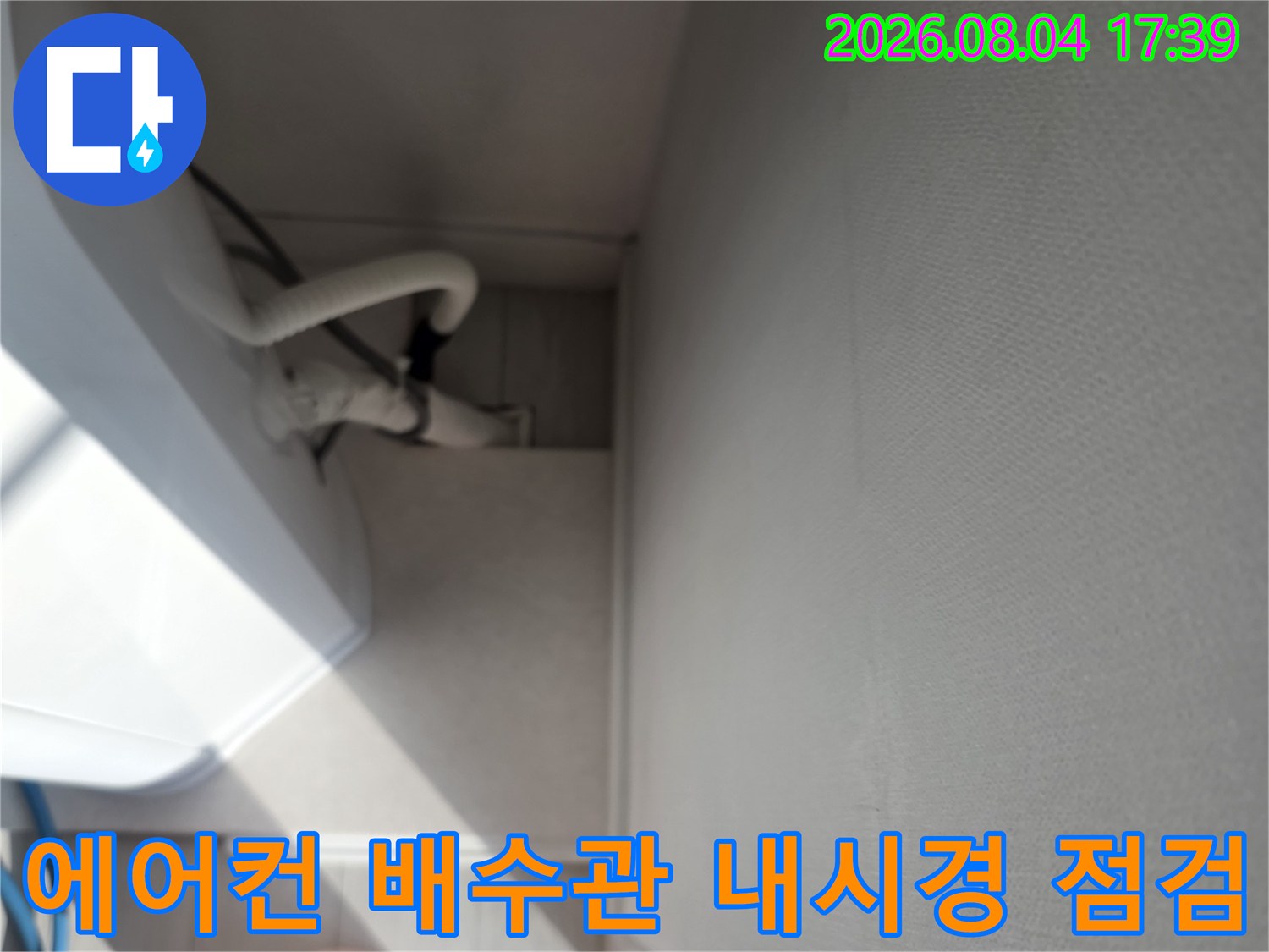 에어컨 드레인 배관을 점검하는 장비와 분홍색 노즐이 배치된 현장 모습