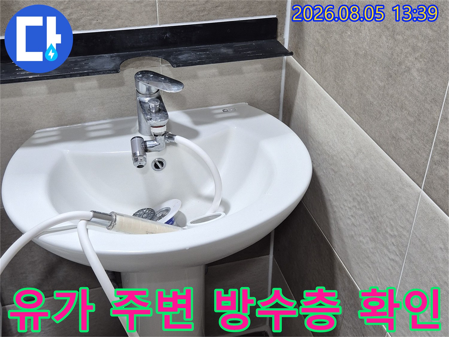 배수구 내부를 노출하여 타일과 배관 사이의 틈을 점검하는 장면