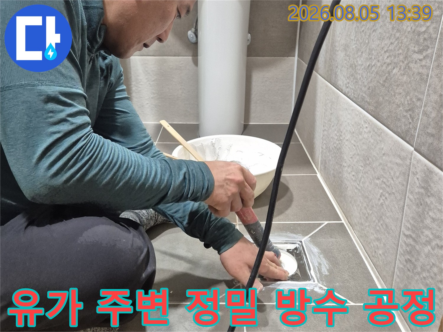 전문가가 화장실 바닥 배수관 주위를 특수한 재료로 꼼꼼하게 메우는 작업 모습