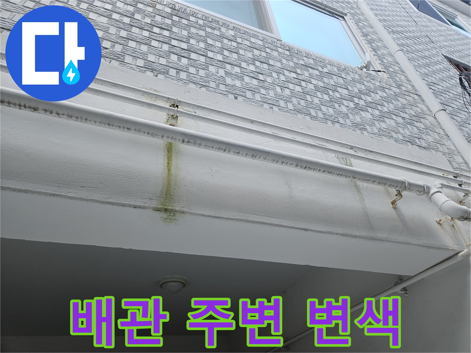 하얀 천장 마감재 위로 배관을 따라 나타난 누수 변색 부위