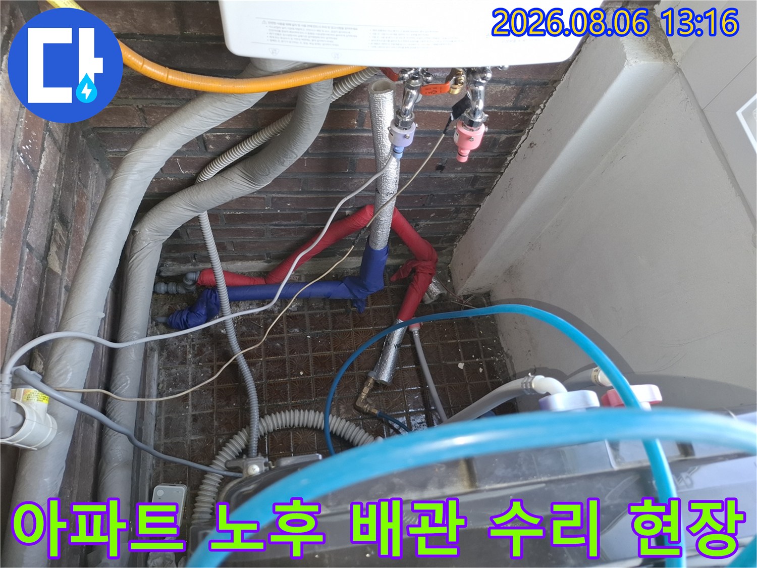 노후된 붉은색과 파란색 배관이 복잡하게 얽힌 세대 내 배관 시스템 점검 모습
