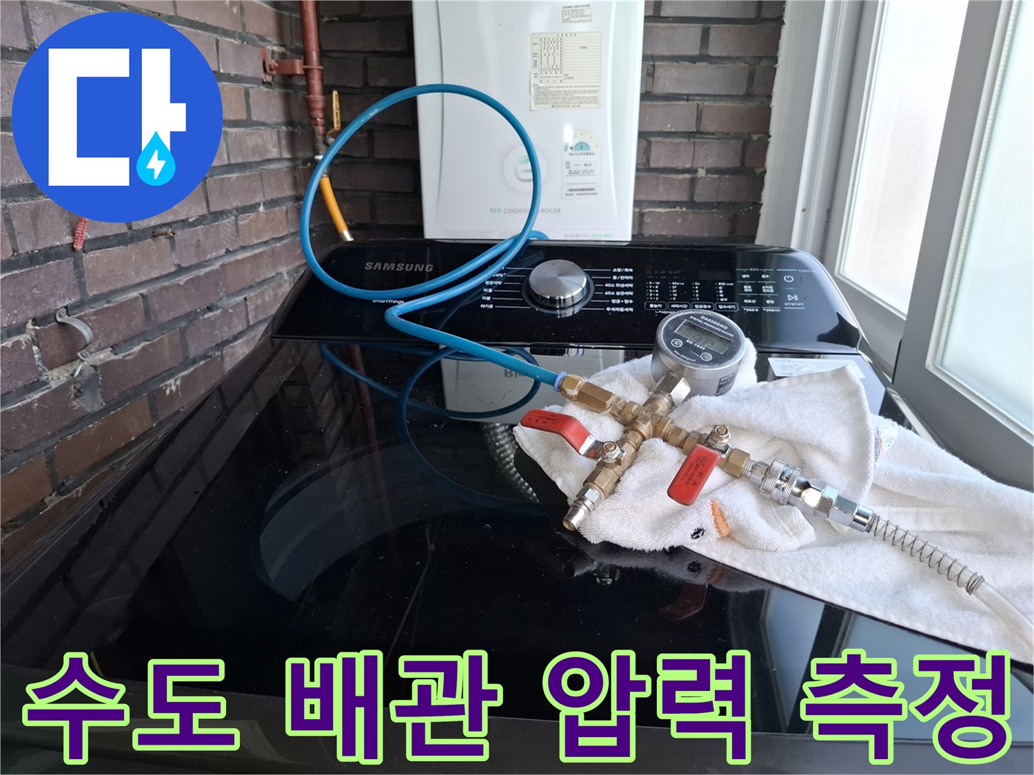 세탁기 상단에 배치된 배관 점검용 압력계와 호스