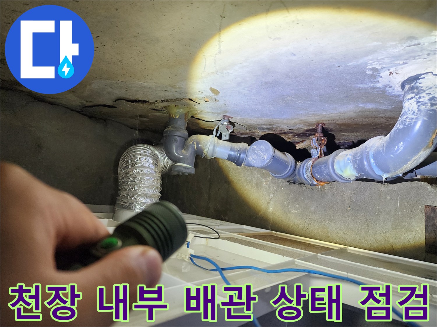 손전등 빛에 드러난-천장 내부 배관과 주변 습기