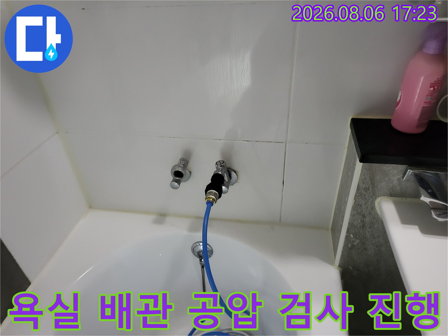 파란색 테스트 호스가 연결된 욕실 벽면 수도 배관 점검 모습