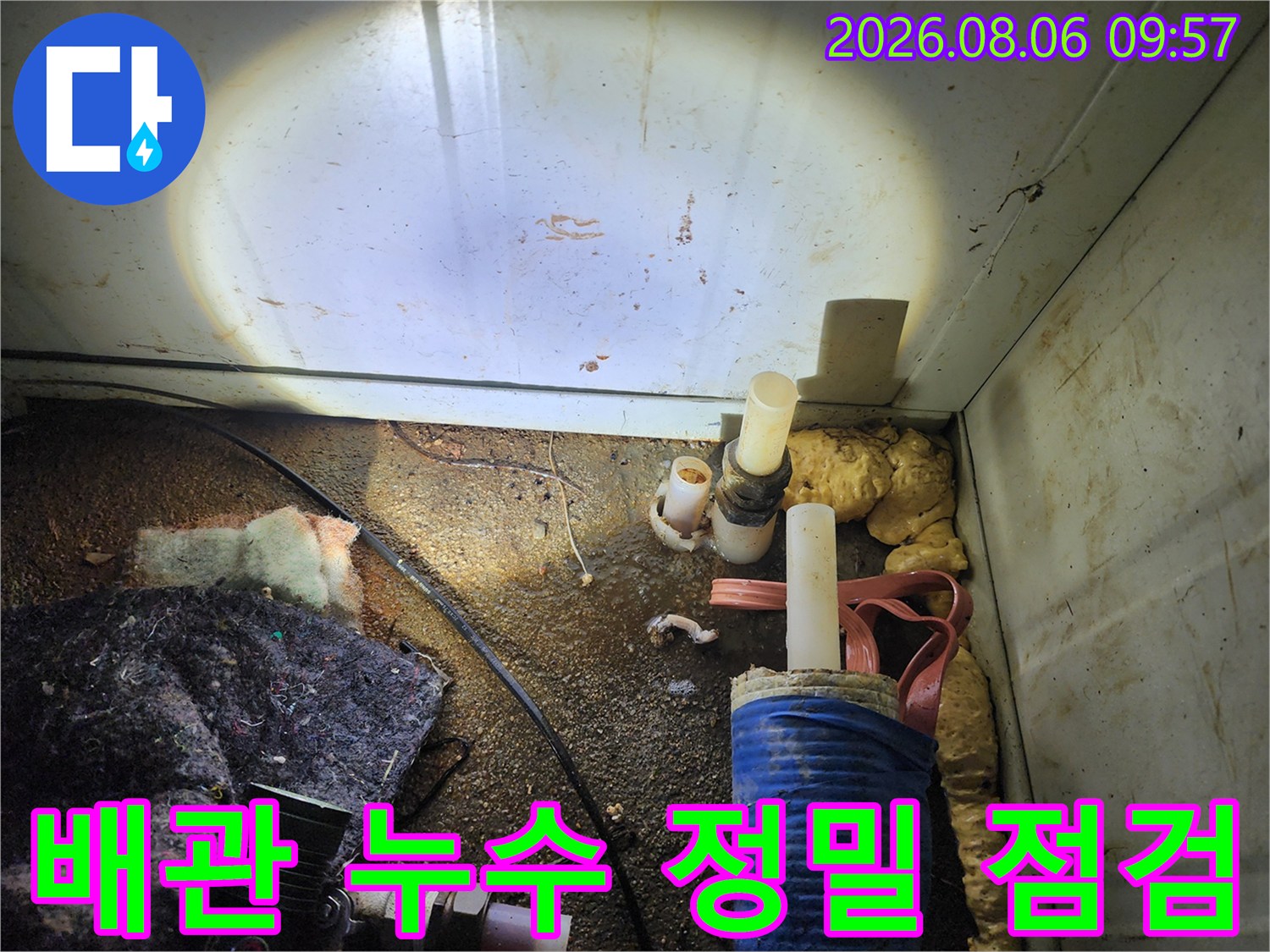 먼지가 많은 공간 속 노출 배관과 교체용 부품이 있는 현장 사진