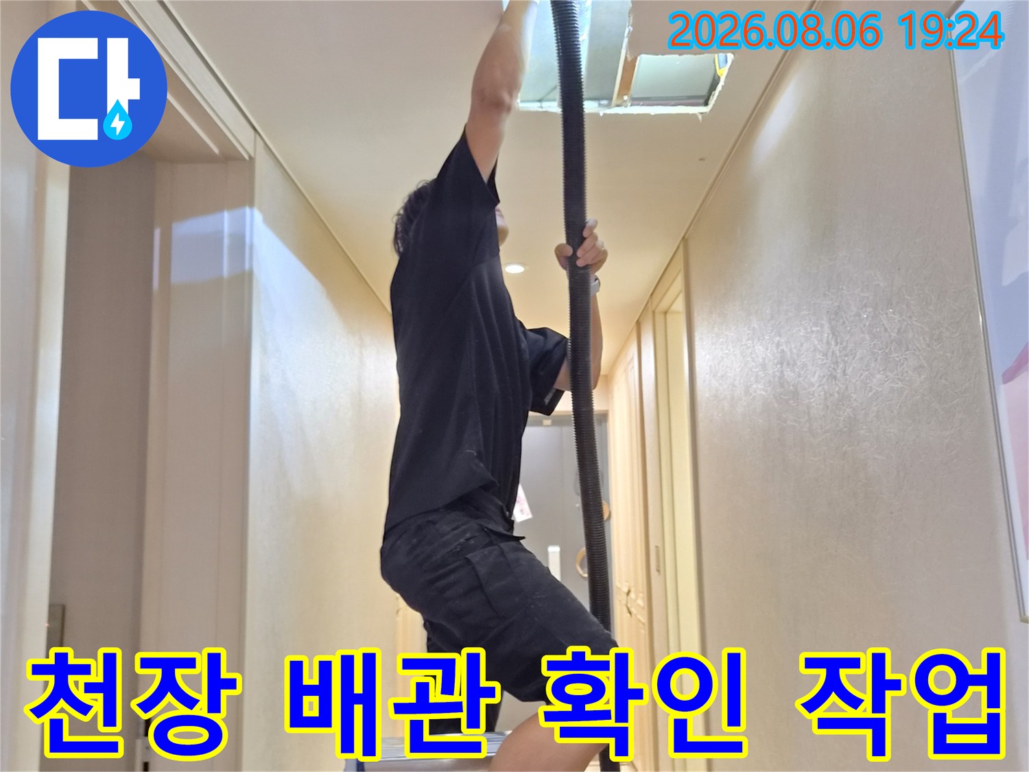 사다리를 타고 올라가 천장 에어컨 배관을 점검하고 있습니다.