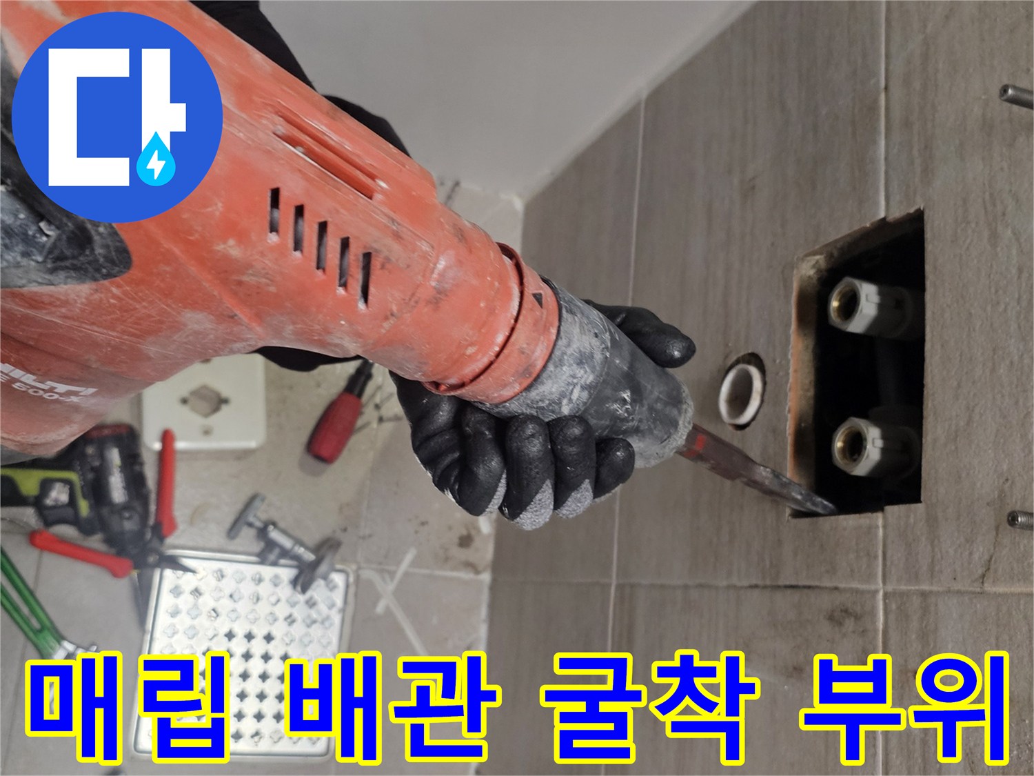 전동 드릴로 타일을 제거하여 드러난 벽 내부 배관 노출 상태